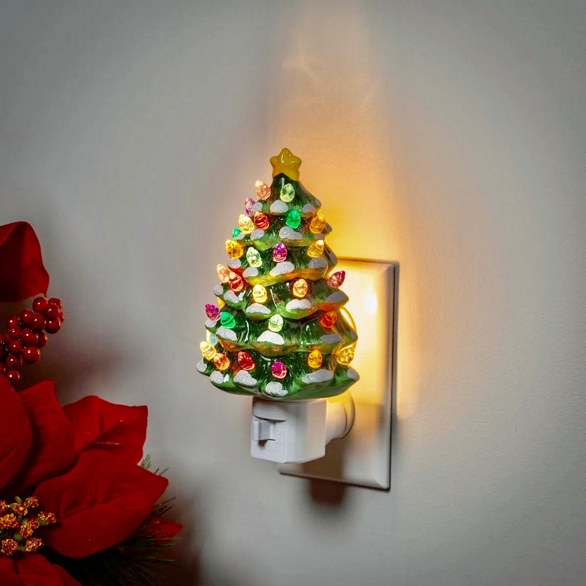 Ceramic Christmas tree nightlight plugged into wall socket