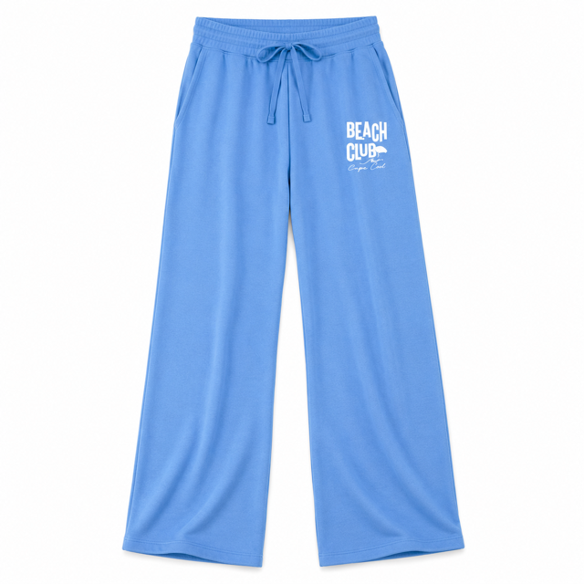 Light blue wide-leg lounge pants with a white 'BEACH CLUB' graphic on the left thigh, featuring an elastic drawstring waistband, photographed on a solid white background.