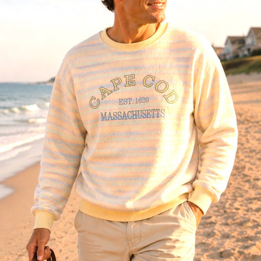Person wearing a 'Cape Cod, Massachusetts' sweater on a beach.